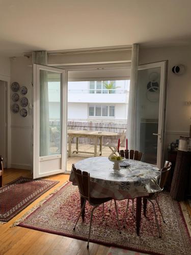 Appartement Terrasse في رويان: غرفة طعام بها طاولة وباب زجاجي منزلق كبير