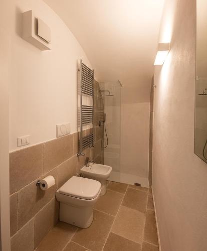 a white bathroom with a toilet and a shower at Janela Blue Civico 35 in Otranto