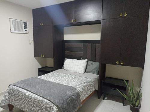 a small bedroom with a bed and brown cabinets at Don Charlie in Veracruz