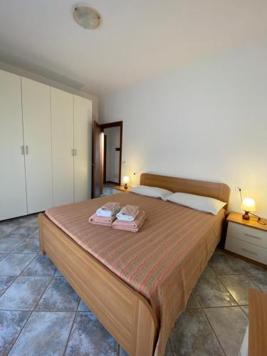 a bedroom with a large bed with two towels on it at Appartamento sole in Vercana