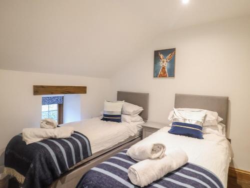 two twin beds in a room with towels on them at Rose Cottage in West Buckland