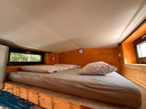 a bed in a small room with two pillows at Tiny House na pevnosti Křelov in Olomouc