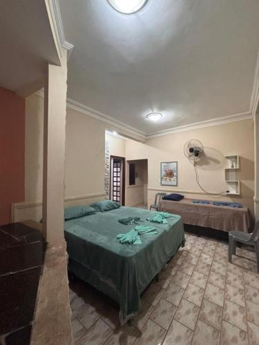 a bedroom with a bed with a green comforter at Sereny Stone Palace in Rondonópolis
