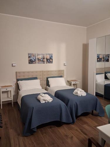a bedroom with two beds with blue blankets on them at Antico Casale San Pantaleone in Sorbolo