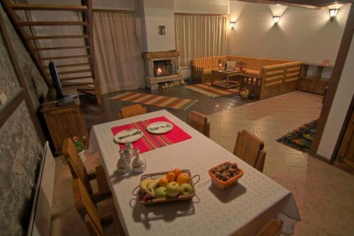 a dining room with a table with a bowl of fruit at Holiday Village Kochorite in Pamporovo