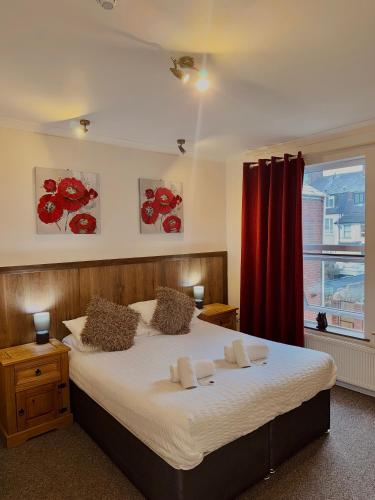 a bedroom with a large bed with a red curtain at Riverside Hotel in Norwich
