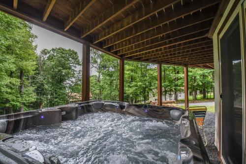 a hot tub on a screened in porch with water at Howling Wolf Den in Oakland