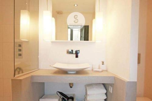 a bathroom with a sink and a mirror at Côté Pur Arles Centre in Arles