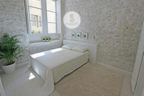 a white bedroom with a bed in a room at Côté Pur Arles Centre in Arles