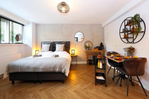 a bedroom with a bed and a table and a desk at B&B Molenhuiszuilichem in Zuilichem