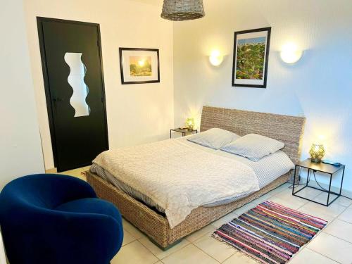 a bedroom with a bed and a blue chair at Vazaha grand et bel appartement classé 3 étoiles in Lavelanet