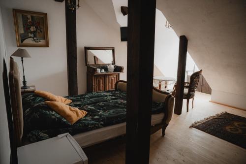 a bedroom with a bed with a green comforter at Apartament w Zabytkowej Stajni nad Jeziorem z Dostępem do Parku i Sąsiedztwem XIX wiecznego Dworku Modrzewiowego in Szteklin