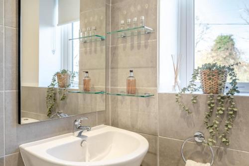 a bathroom with a sink and a mirror and a window at 2 Bed in Sticklepath oc-l33312 in Sticklepath