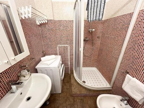 a bathroom with a shower and a sink and a toilet at porta merlonia house minimono in Forlì