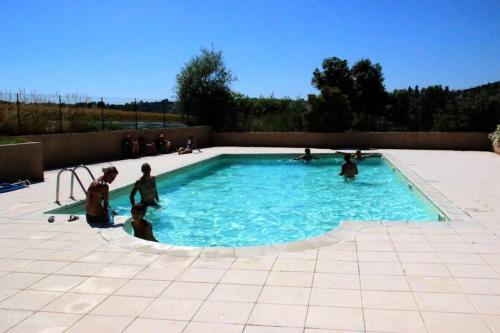 a group of people playing in a swimming pool at ZEcamping 3 dog friendly avec piscine au bord du lac de la Thésauque in Nailloux