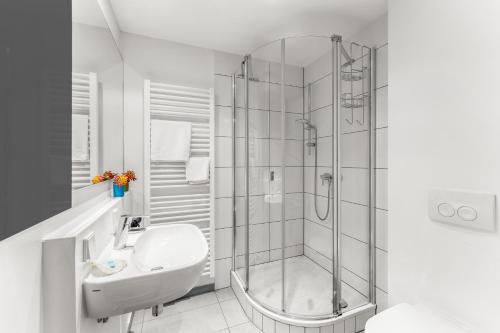 a white bathroom with a shower and a sink at ParkVilla Puschendorf, 24-7 Self-Check-in in Puschendorf