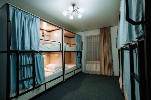 a room with two bunk beds with a ceiling fan at Азия Hostel in Shymkent