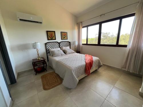 a bedroom with a bed and a large window at Brisas Vista Serena in Nueva Gorgona