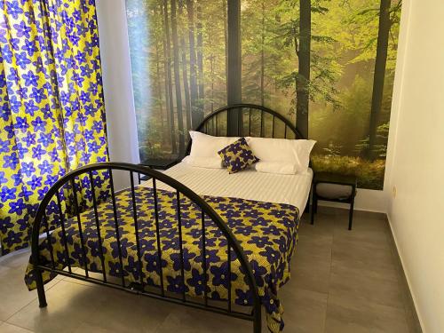 a bedroom with a bed and a large window at une chambre dépaysante in Tarrafal