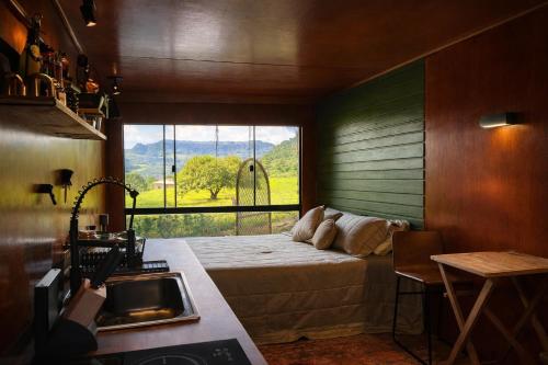 a bedroom with a bed and a large window at Cabana estilo Glamping com Banheiras Quente e Vista às Montanhas in Rio do Sul