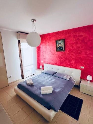 a bedroom with a blue bed with a red wall at Appartamento Carino Splendido Trivano Panoramico IUN S3308 in Quartucciu