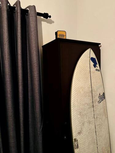 a surfboard is standing next to a black curtain at Diddi's in Weligama