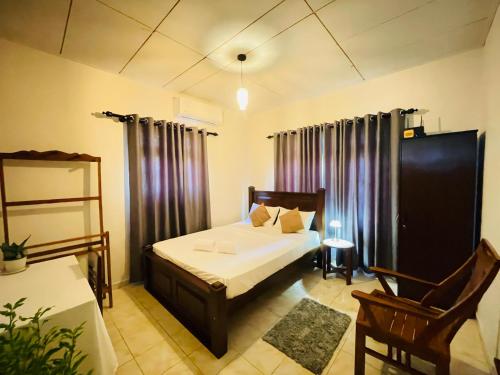 a bedroom with a bed and a chair in a room at Diddi's in Weligama
