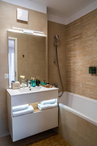a bathroom with a sink and a tub and a mirror at Cliché Luxury Apartment in Braşov