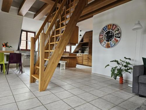 a kitchen and a living room with a wooden staircase at Ferienwohnung 2 ANNA IFF in Würzburg