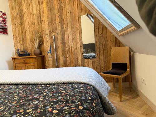 a bedroom with a bed and a window and a chair at Schaapskooi 20 in Dwingeloo