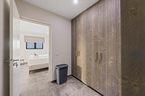 a bathroom with a large wooden closet and a bedroom at Penthouse Casa James, Mambo Beach, Jacuzzi & Sea View in Willemstad