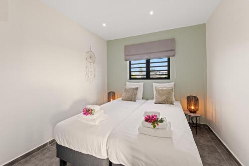 a bedroom with a large white bed with flowers on it at Penthouse Casa James, Mambo Beach, Jacuzzi & Sea View in Willemstad