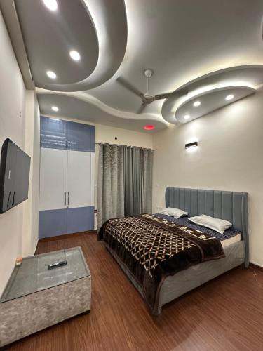 a bedroom with a large bed and a tv at Dream heaven in Greater Noida