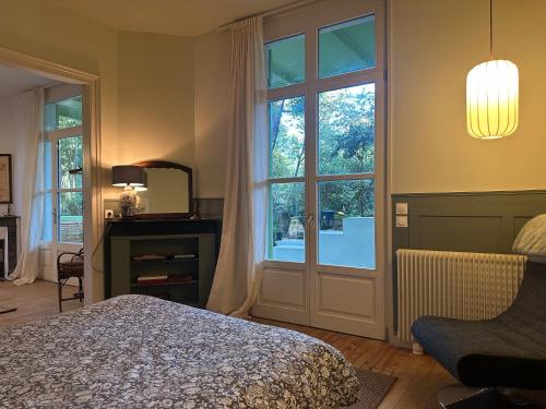 a bedroom with a bed and a large window at Les Mimosas in Arcachon