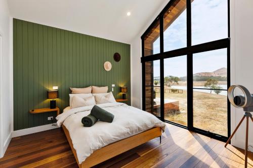 a bedroom with a large bed with a green wall at The Barn Bonnie Doon in Bonnie Doon