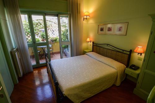 a bedroom with a bed in a room with a balcony at Lilium Boutique Hotel in Rome