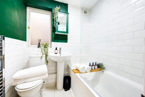 a bathroom with a toilet and a sink and a tub at East London 2 bedrooms flat in London