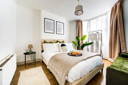 a bedroom with a bed with a bowl of fruit on it at East London 2 bedrooms flat in London