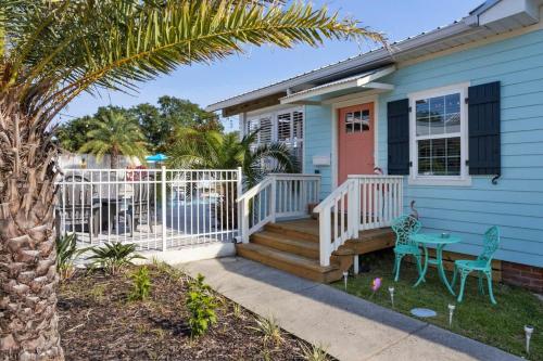 a blue house with a pink door and a table and chairs at Suite Flamingo Pointe with Shared POOL in Bay Saint Louis