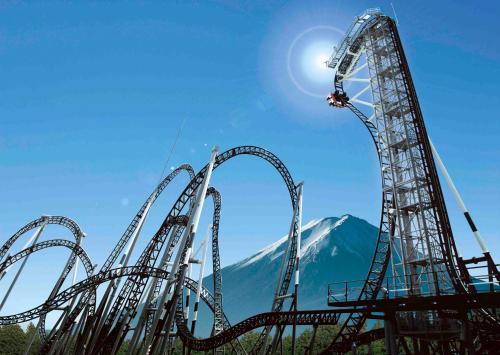 a roller coaster with a mountain in the background at ホステル富士山 結 in Fujiyoshida