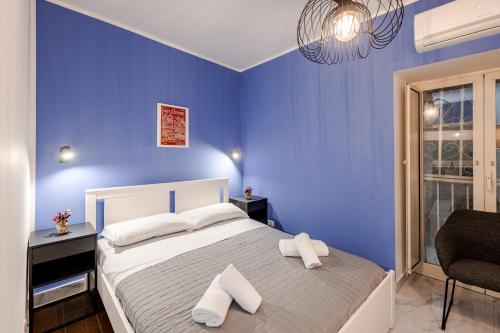 a blue bedroom with a bed with two white pillows at Nalusa - al centro della riviera di chiaia in Naples