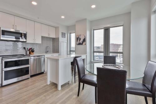 a kitchen with a glass table and black chairs at Spacious Apt Downtown in Quincy