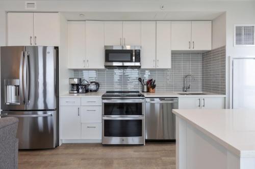 a kitchen with white cabinets and stainless steel appliances at Spacious Apt Downtown in Quincy