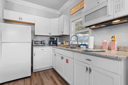 a kitchen with white cabinets and a white refrigerator at Suite - Knome Dome with Shared Pool in Bay Saint Louis