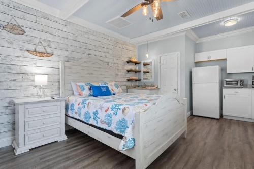 a white bedroom with a bed and a refrigerator at Suite - Knome Dome with Shared Pool in Bay Saint Louis