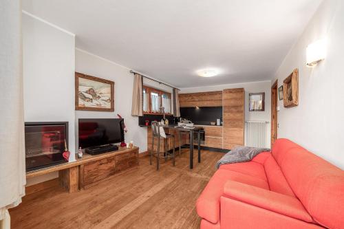 a living room with a red couch and a television at Maison Carrel Elegant 8 in Breuil-Cervinia