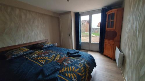 a bedroom with a bed and a large window at le pied des monts in Sainte-Consorce