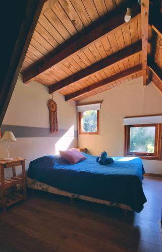 a bedroom with a blue bed and two windows at Complejo Aiken in Villa Traful