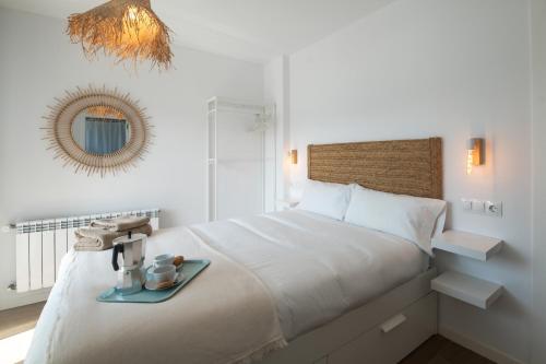 a white bedroom with a bed with a tray on it at Ribadesella Casa con Jardín a 2 km Playa – Saelia in Ribadesella