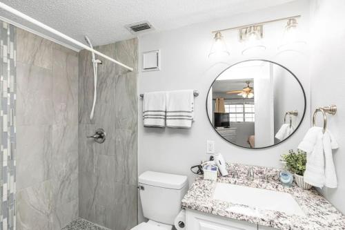 a bathroom with a shower and a sink and a mirror at Islandwood in Fort Walton Beach